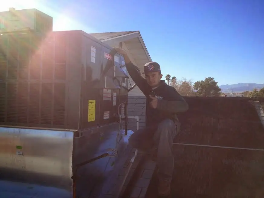 HVAC technician performing Air Duct Cleaning on a rooftop unit in Galion
